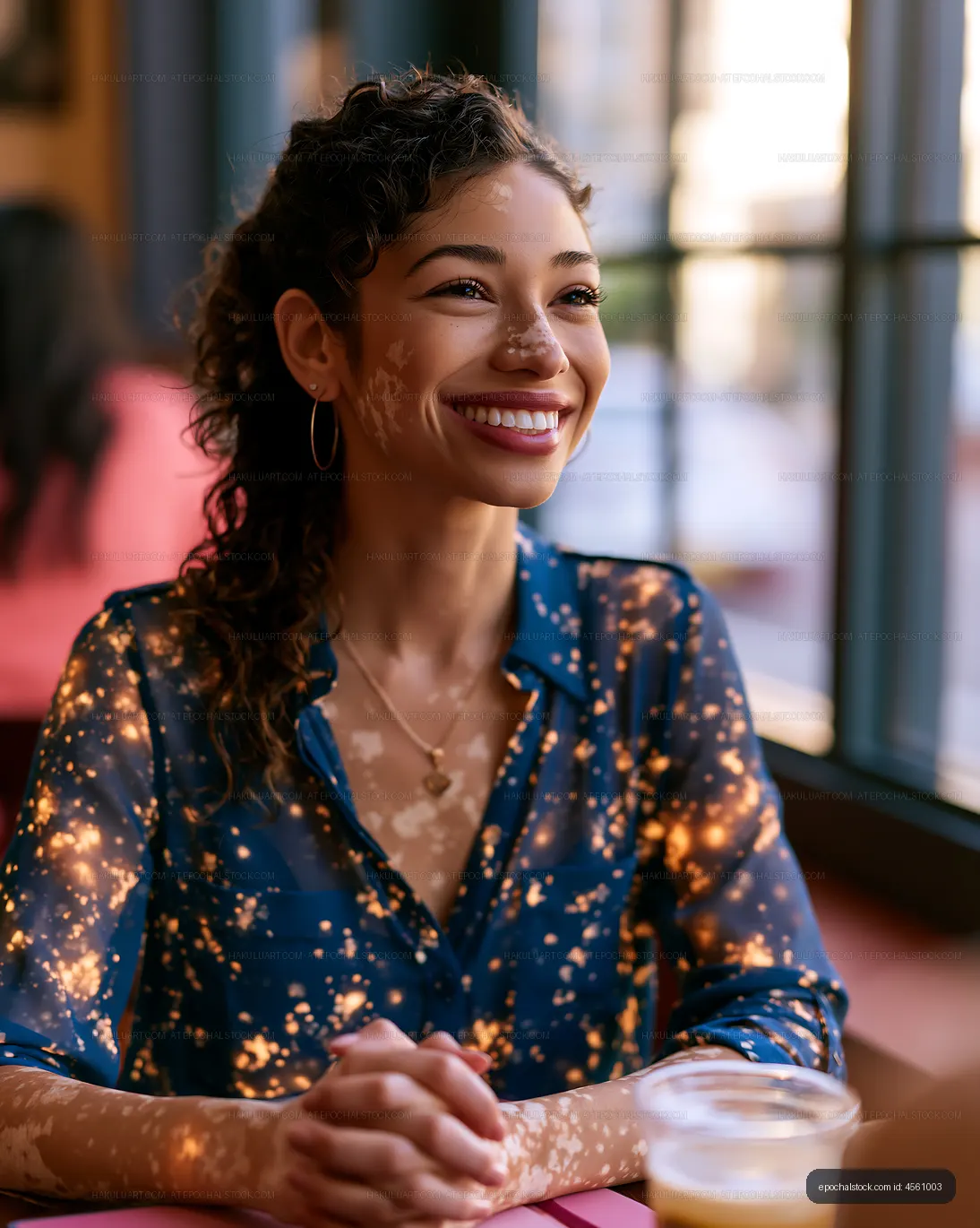 Woman smiling at a cafe with sunlight filtering through windows