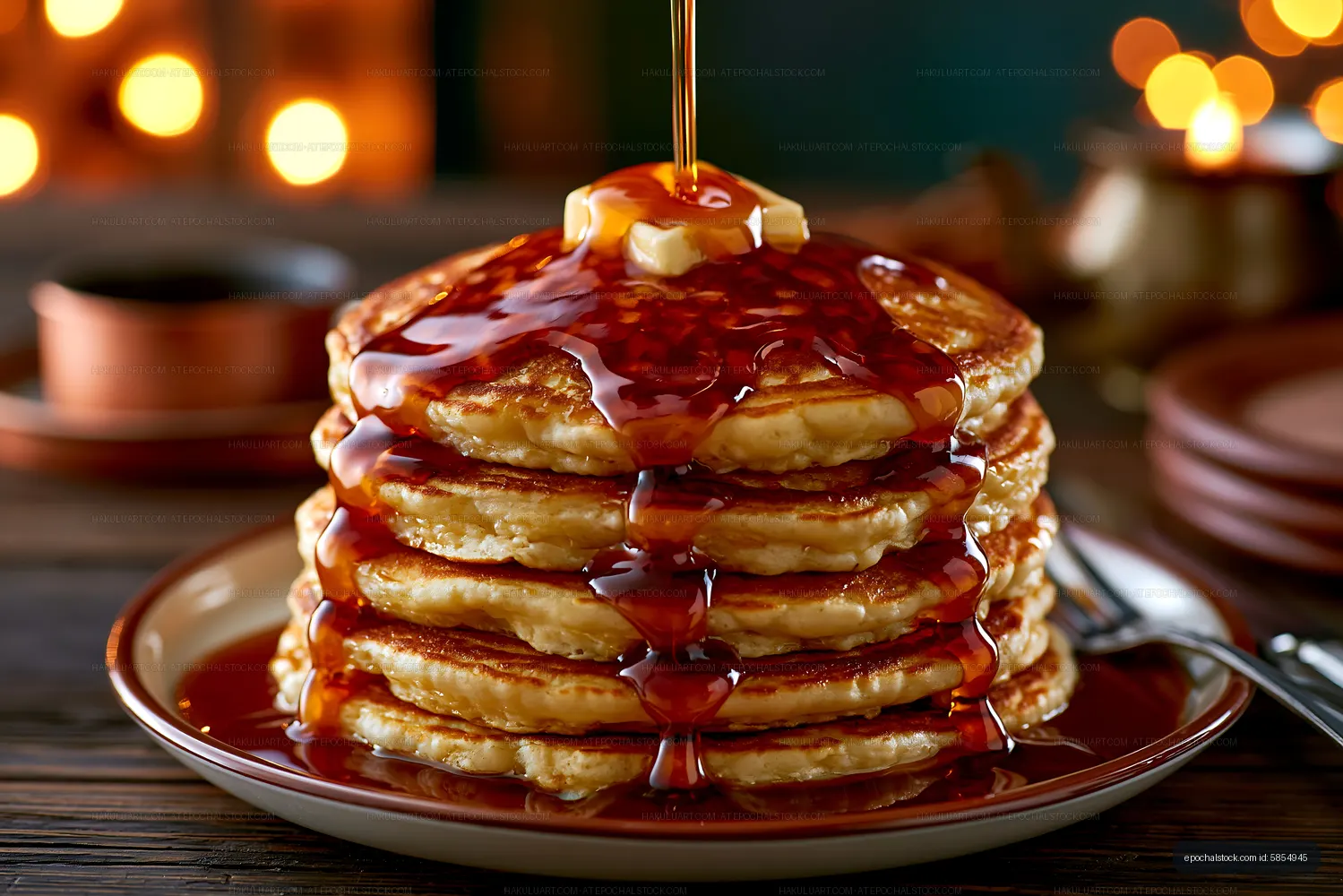 Stack of pancakes with syrup and butter on a wooden table
