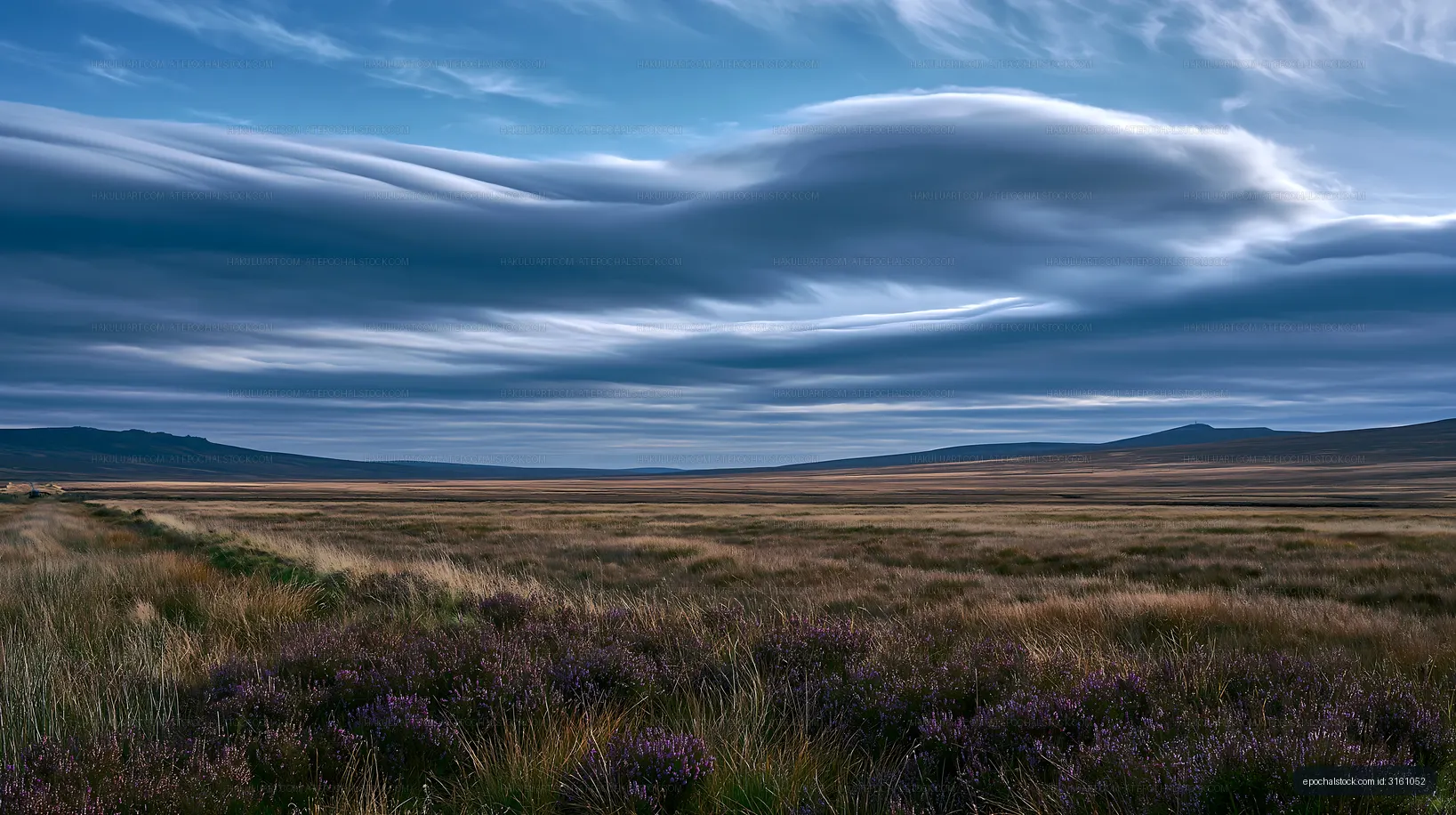Clouds over grassy field in a rural landscape