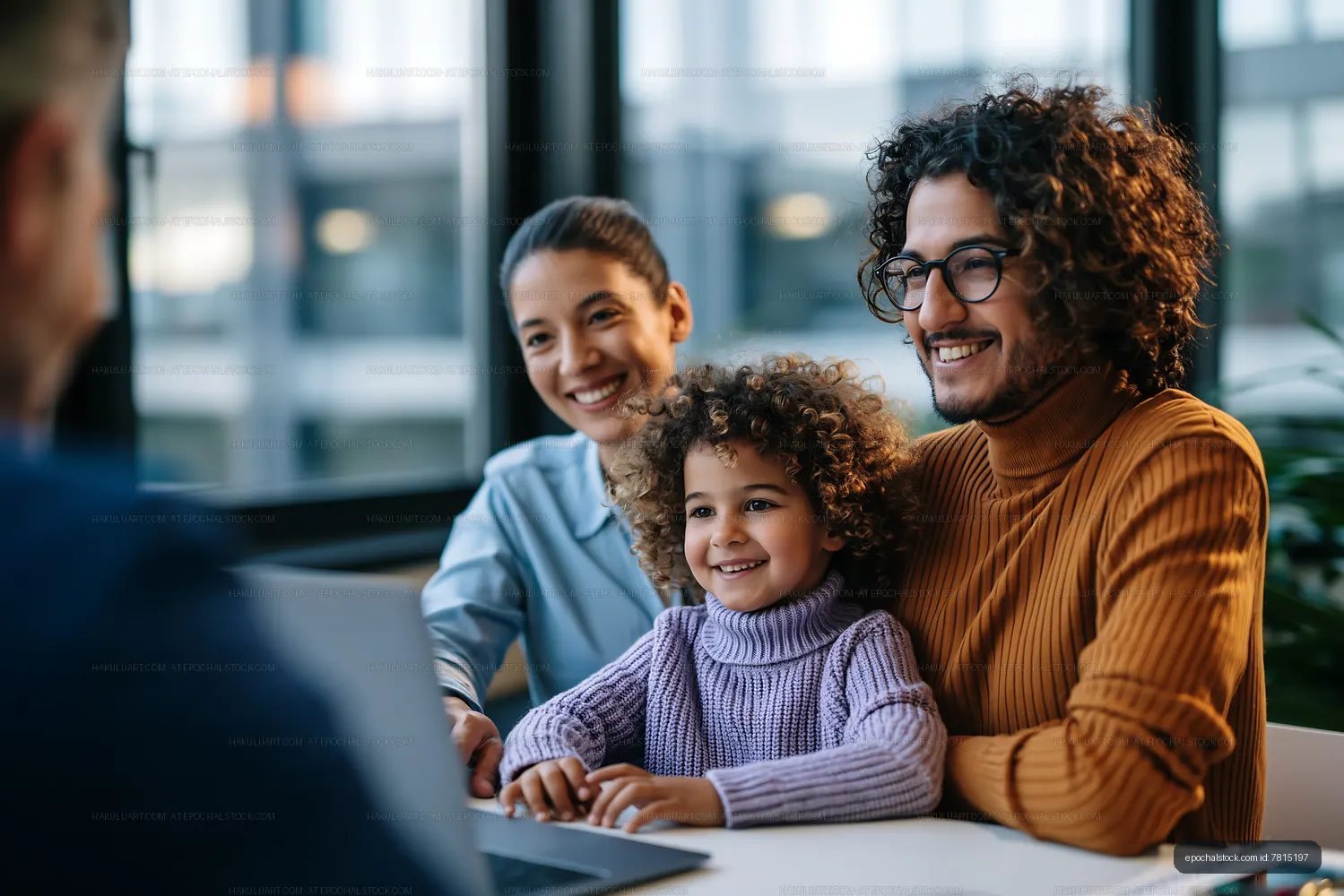 Family enjoying time together at a table with laptop