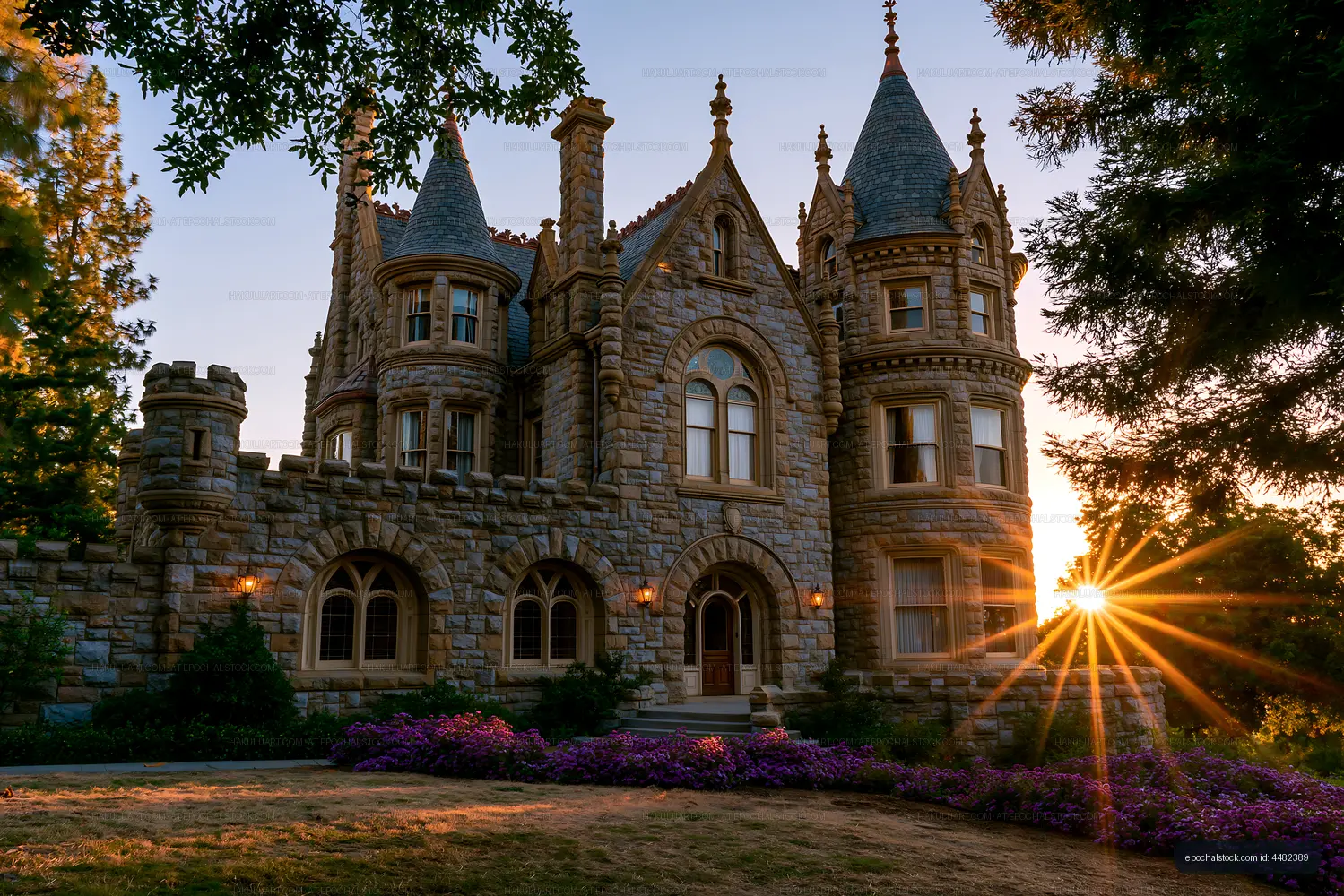 Historic stone mansion with turrets at sunset