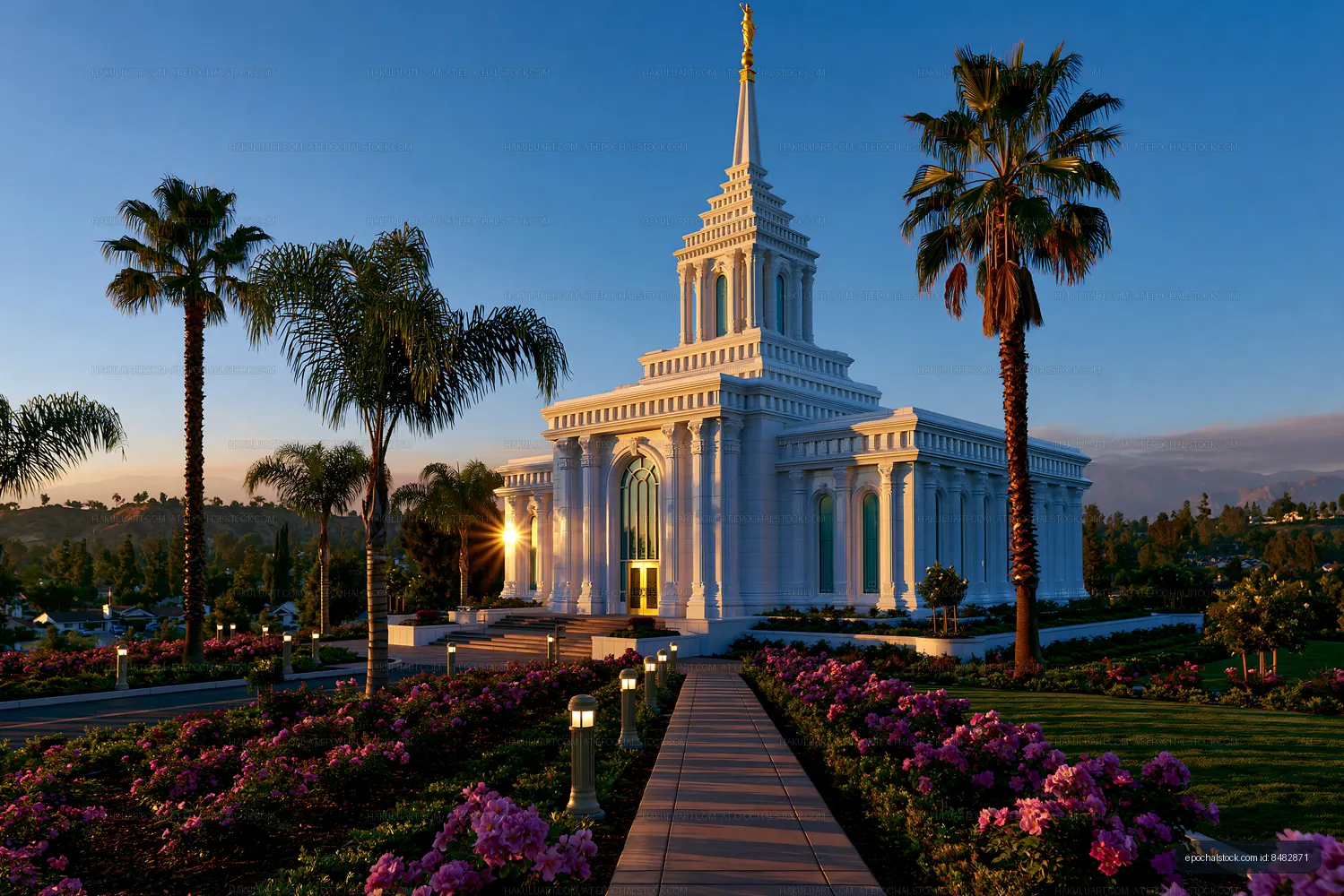 Sunset view of a temple with palm trees and colorful flowers