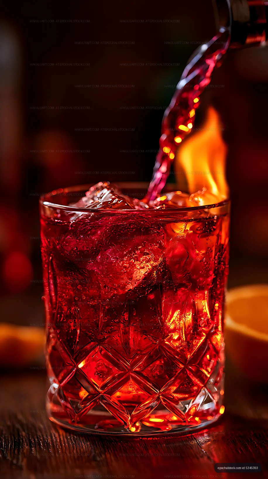 Red cocktail with ice served in a glass on wooden table