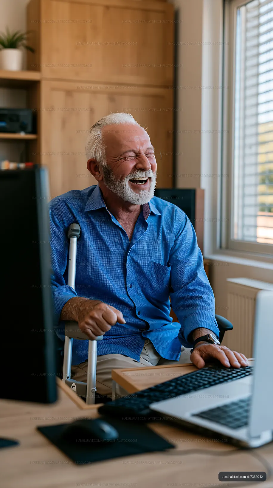 Senior man using computer at home office with cane