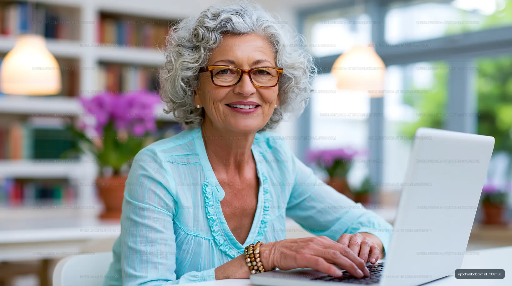 Elderly woman using laptop at home with plants in background