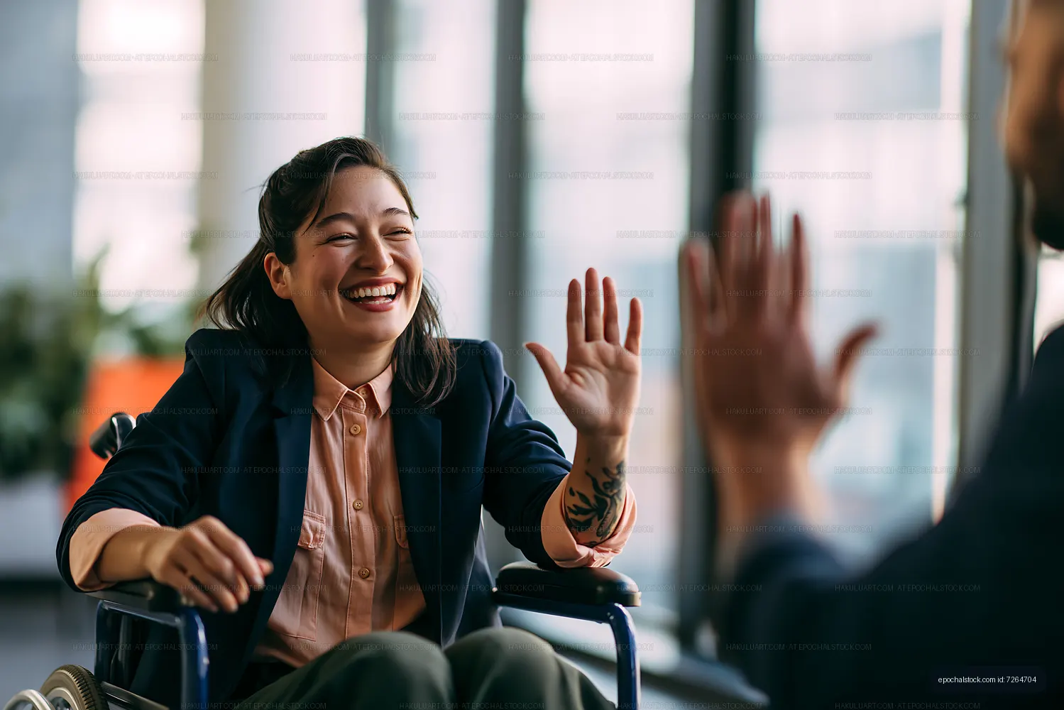 Smiling woman in wheelchair greeting a friend indoors