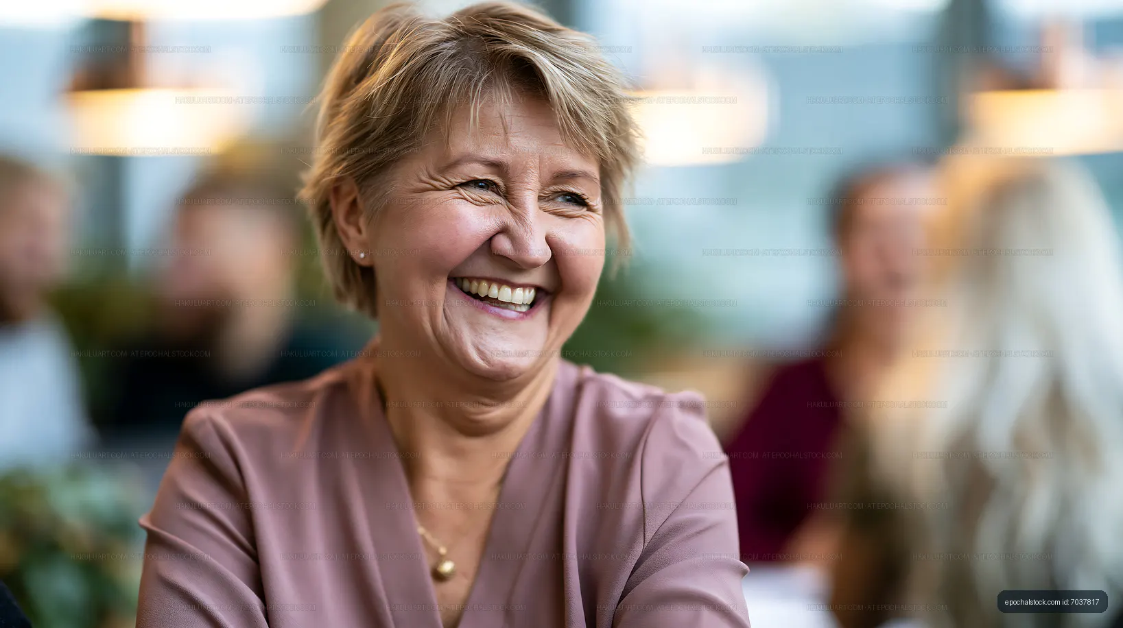 Mature woman laughing during an indoor gathering