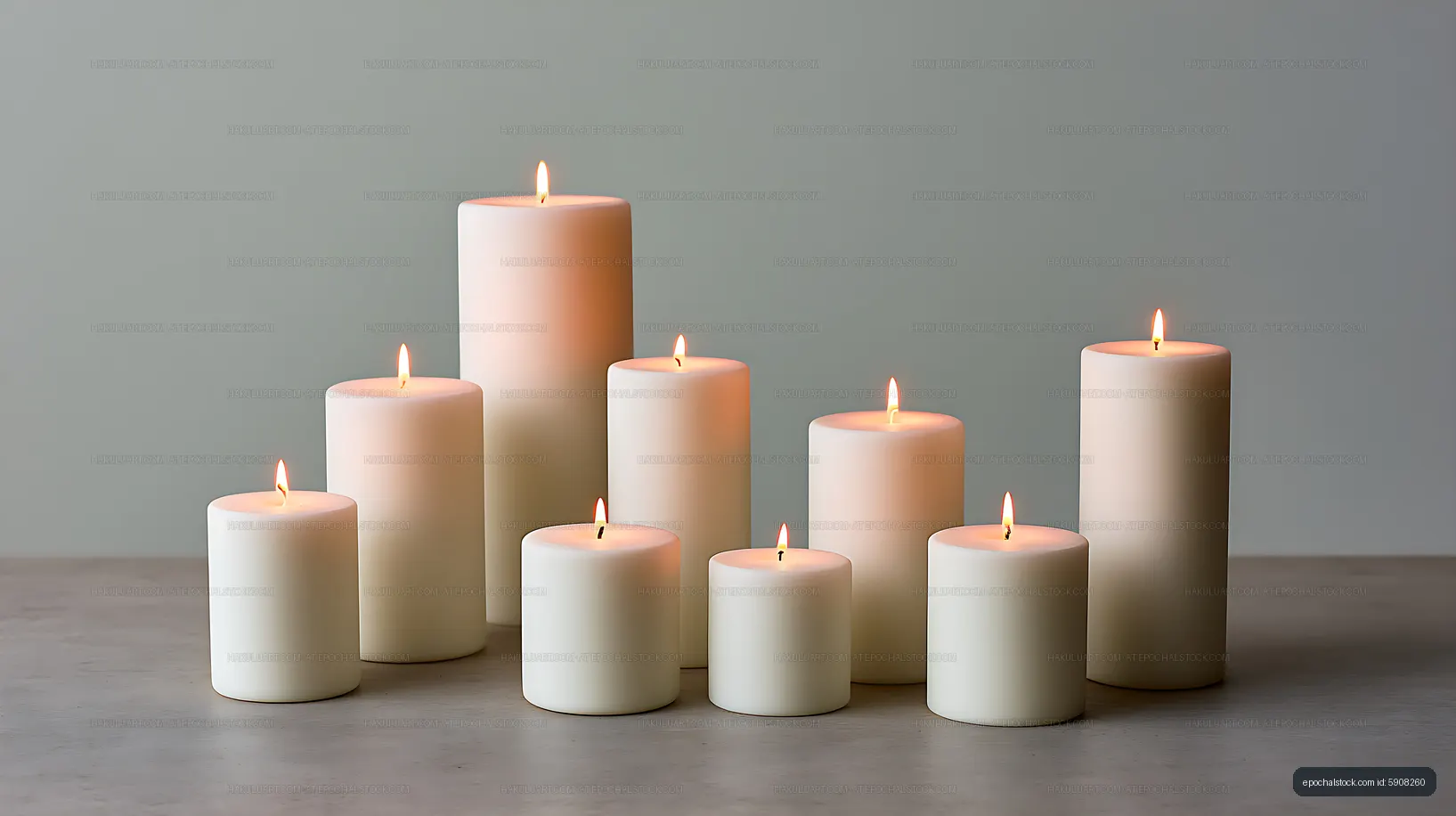 White pillar candles with flames in a minimalist tabletop arrangement
