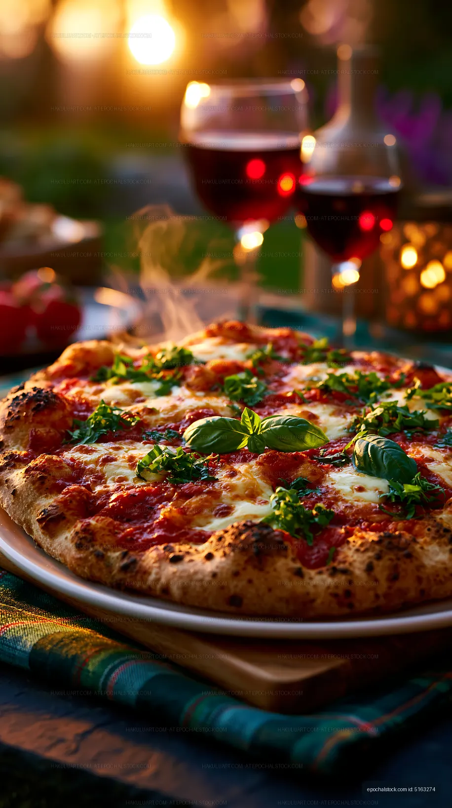 Close-up pizza with basil and wine glasses at dinner