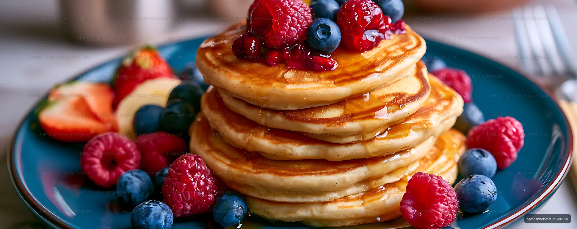 Pancake stack with raspberries, blueberries, and syrup