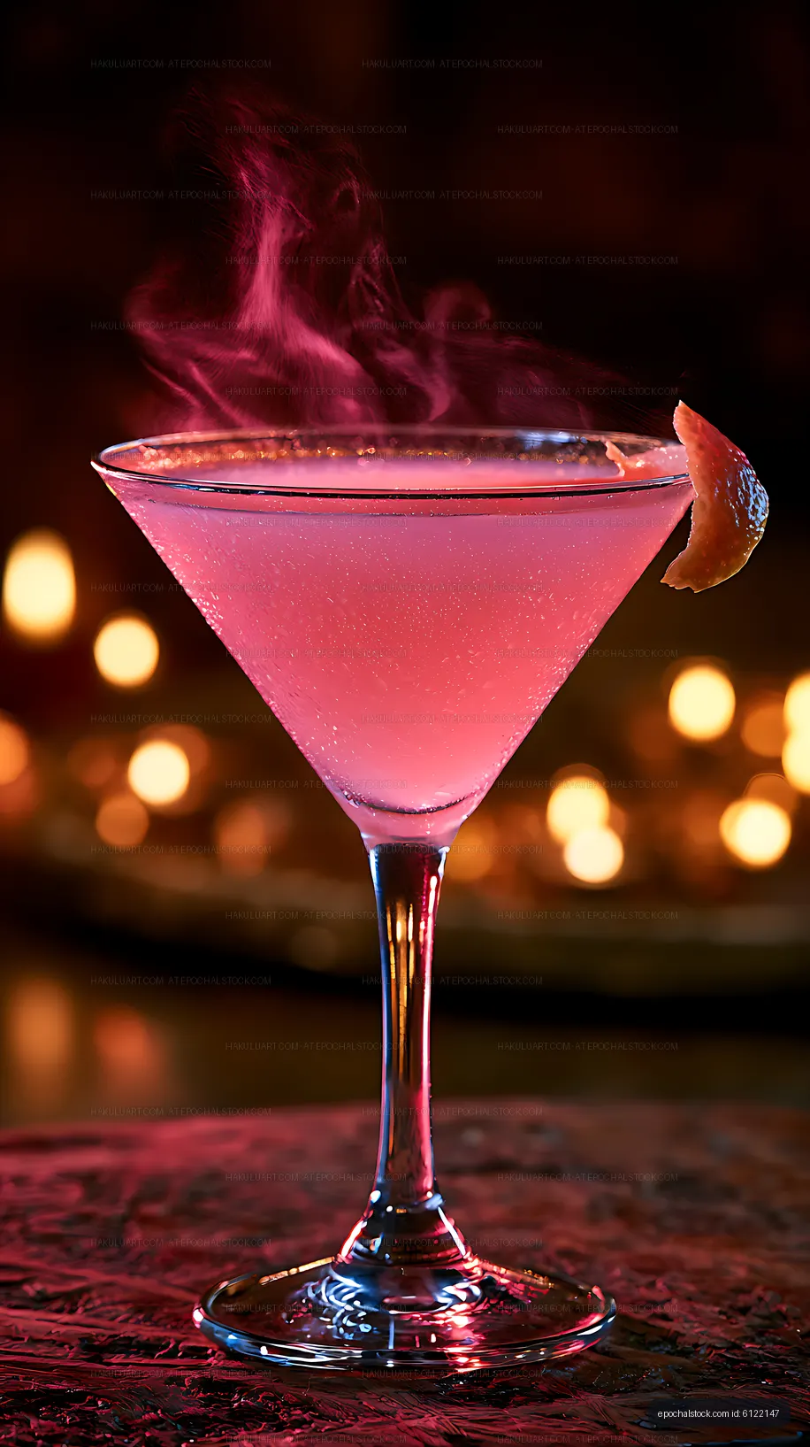 Pink martini cocktail with citrus garnish against glowing bokeh