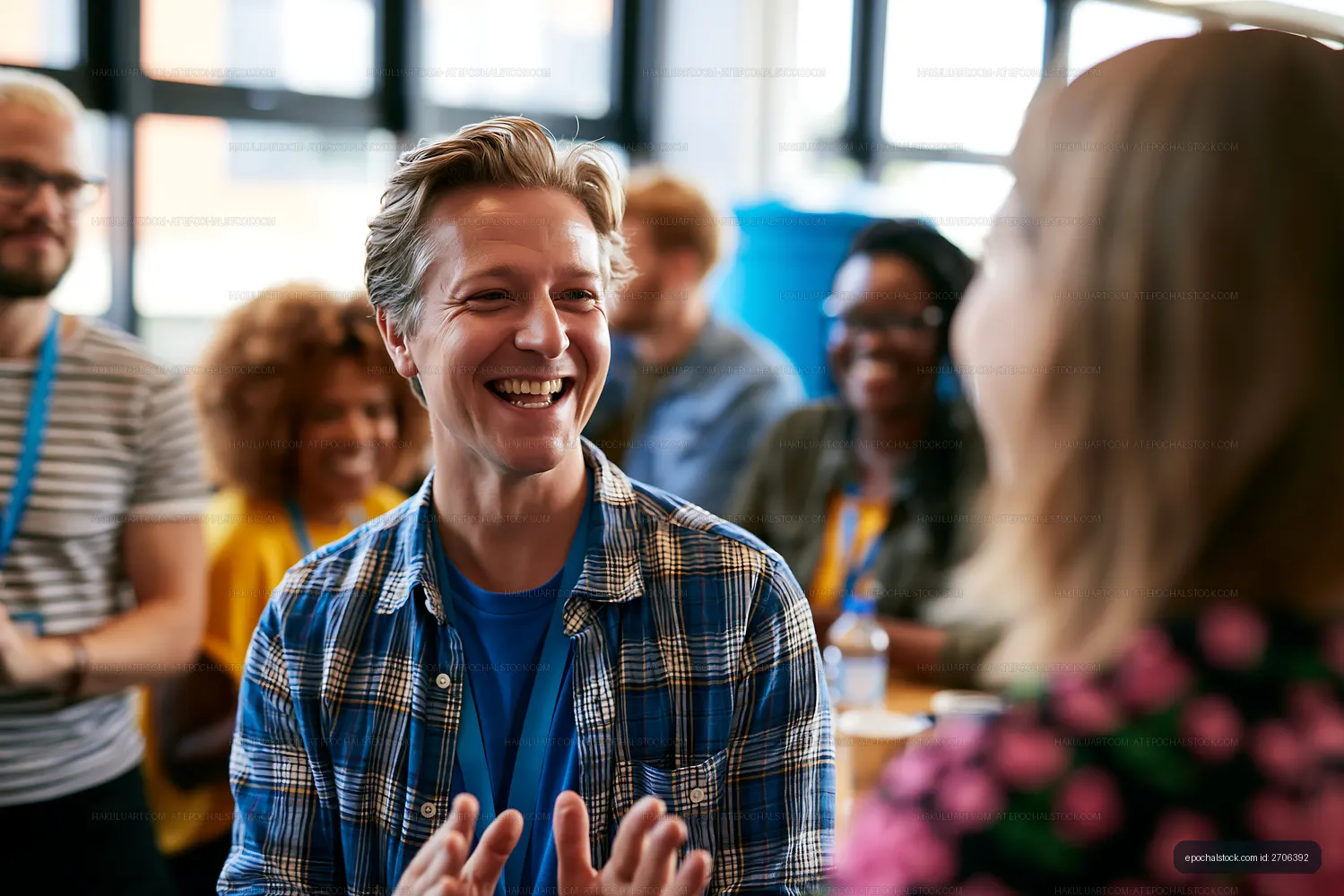 Smiling man gesturing during conversation in a bright indoor gathering