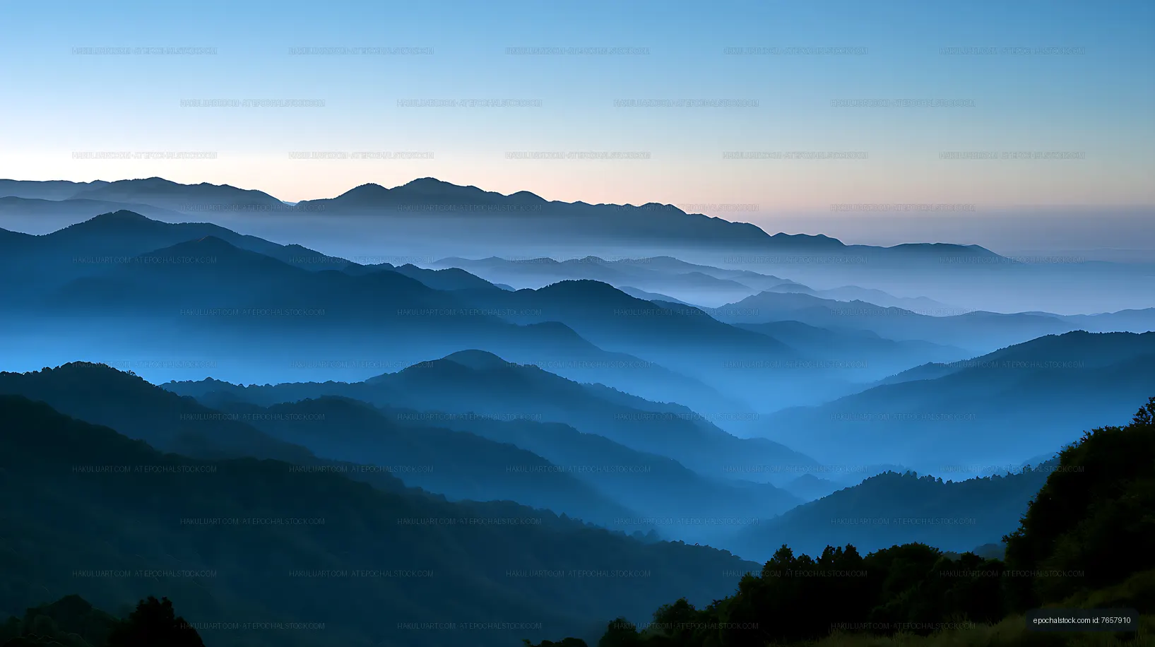 Blue mountain ridges fading into dawn mist