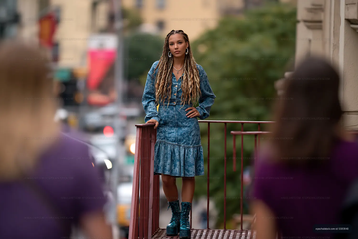 Woman in denim outfit standing on urban pedestrian bridge