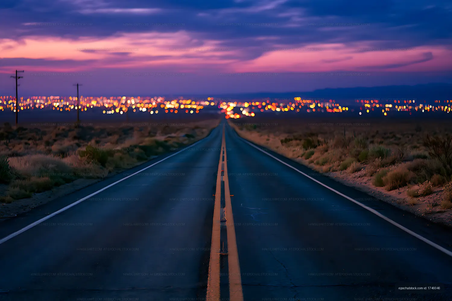 Straight road through desert toward lights at twilight