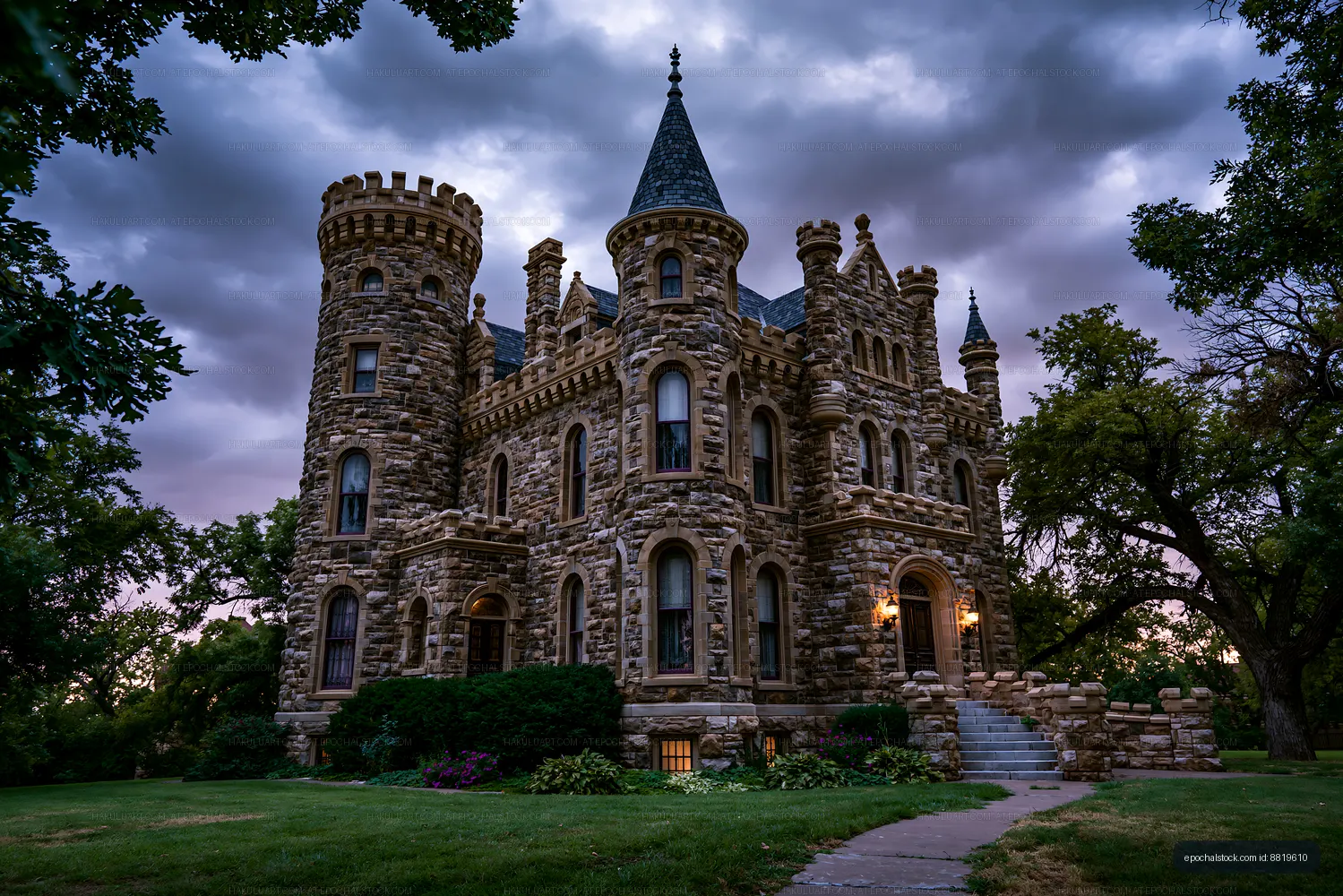 Turreted stone mansion framed by trees and storm clouds