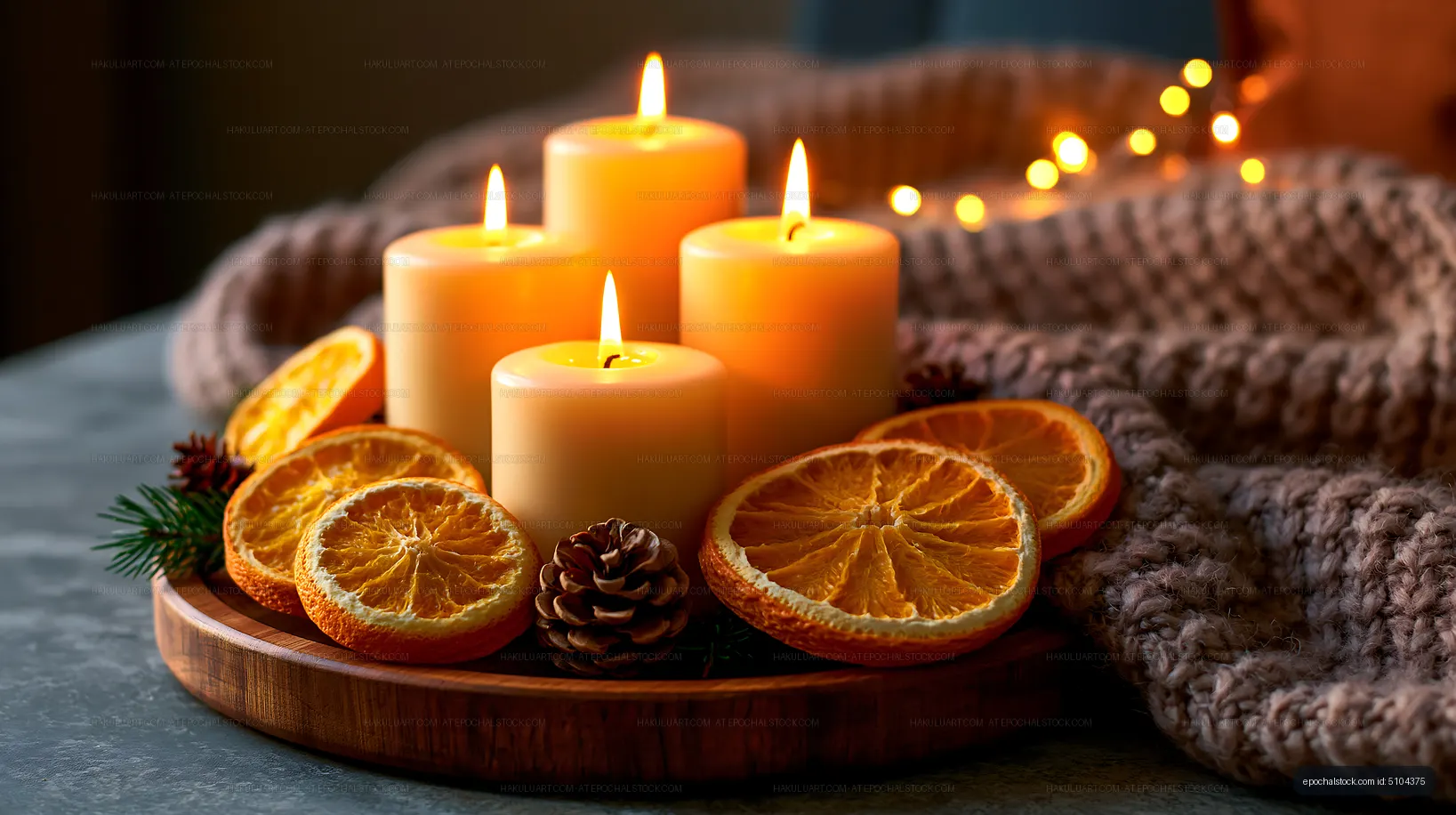 Warm candle still life with citrus, pine cone, and soft lights