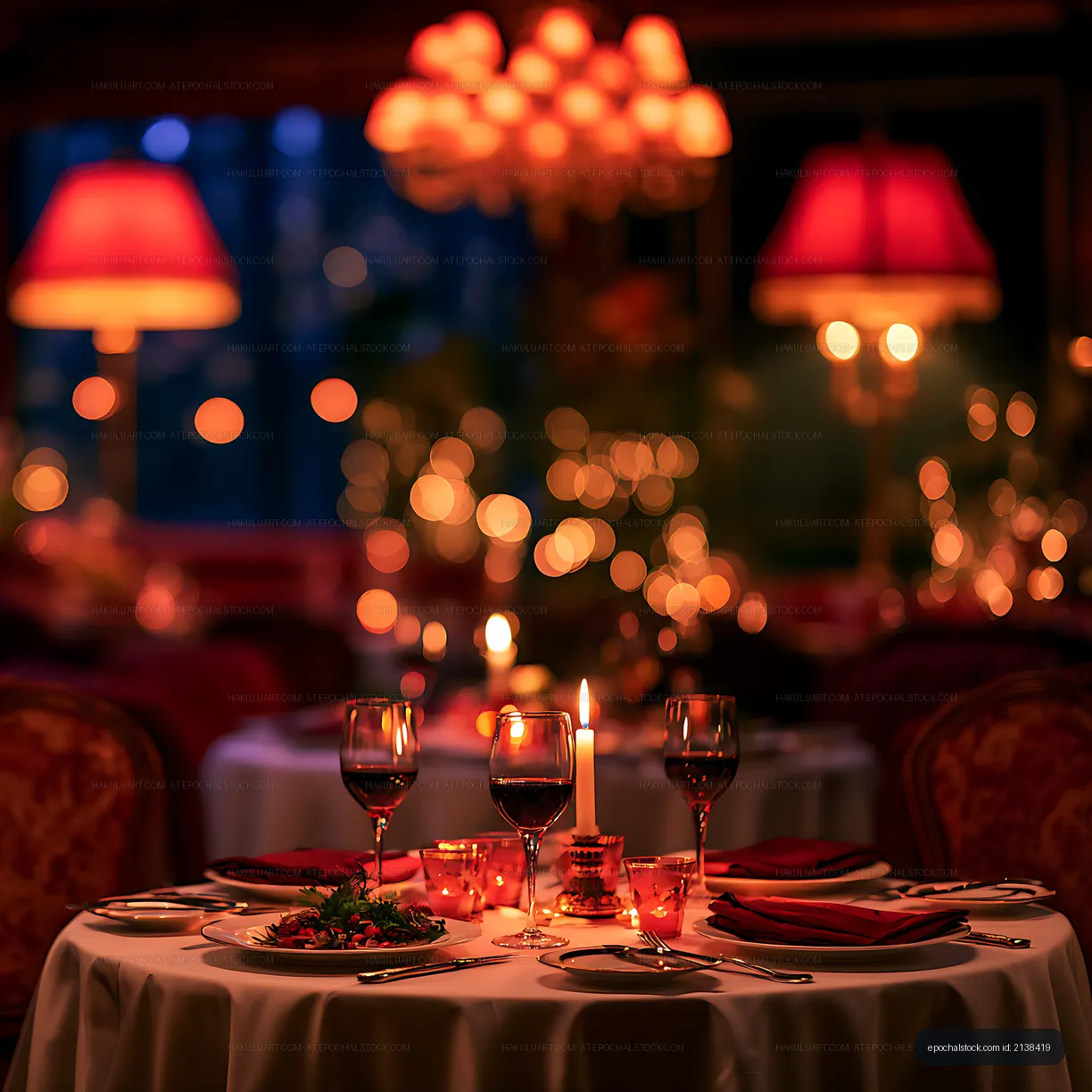 Warm romantic dining table with candles and red wine
