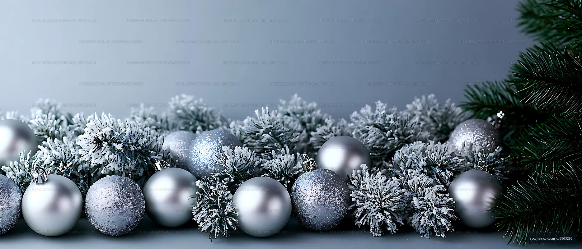 Silver baubles nestled in snowy evergreen branches