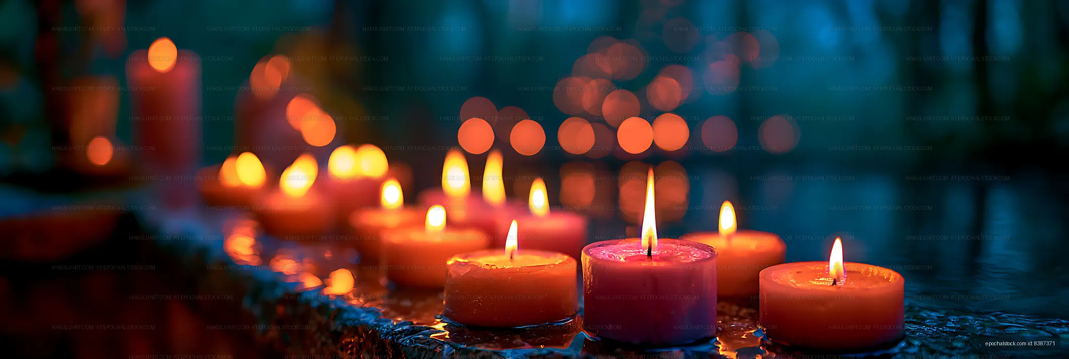 Candle flames glowing against a dark reflective background