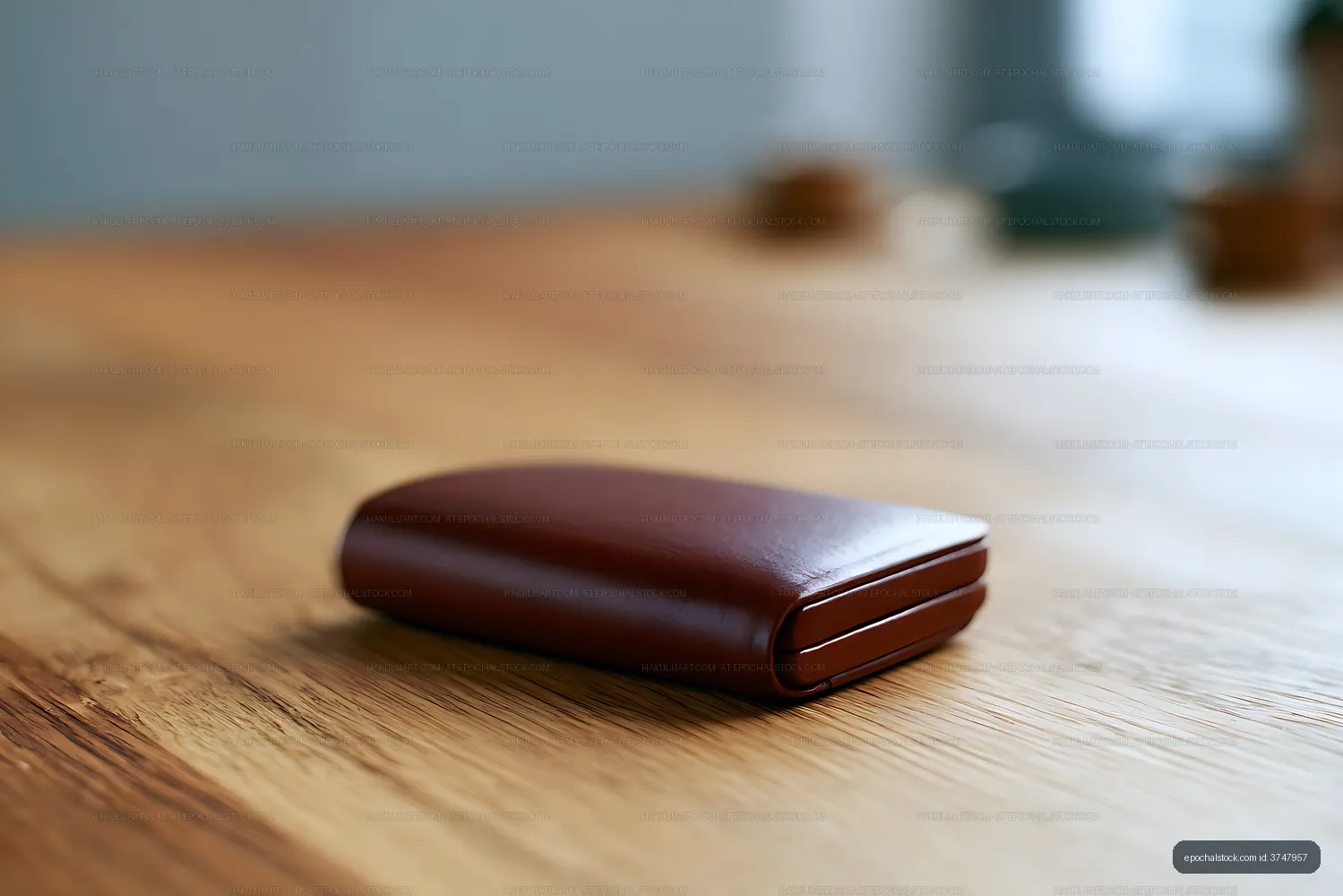 Closed leather wallet on a warm wooden surface
