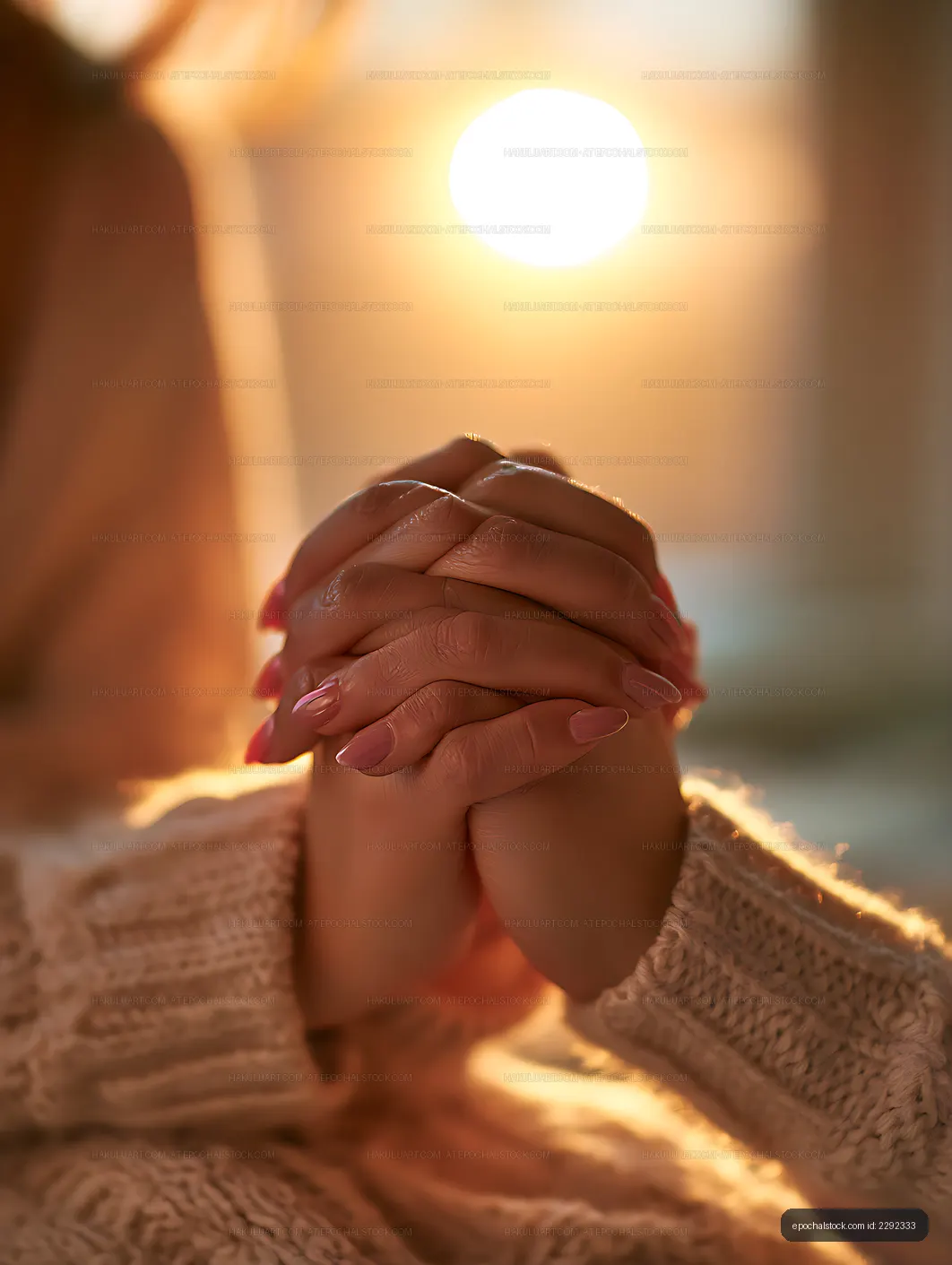 Clasped hands and knit sweater in warm backlight