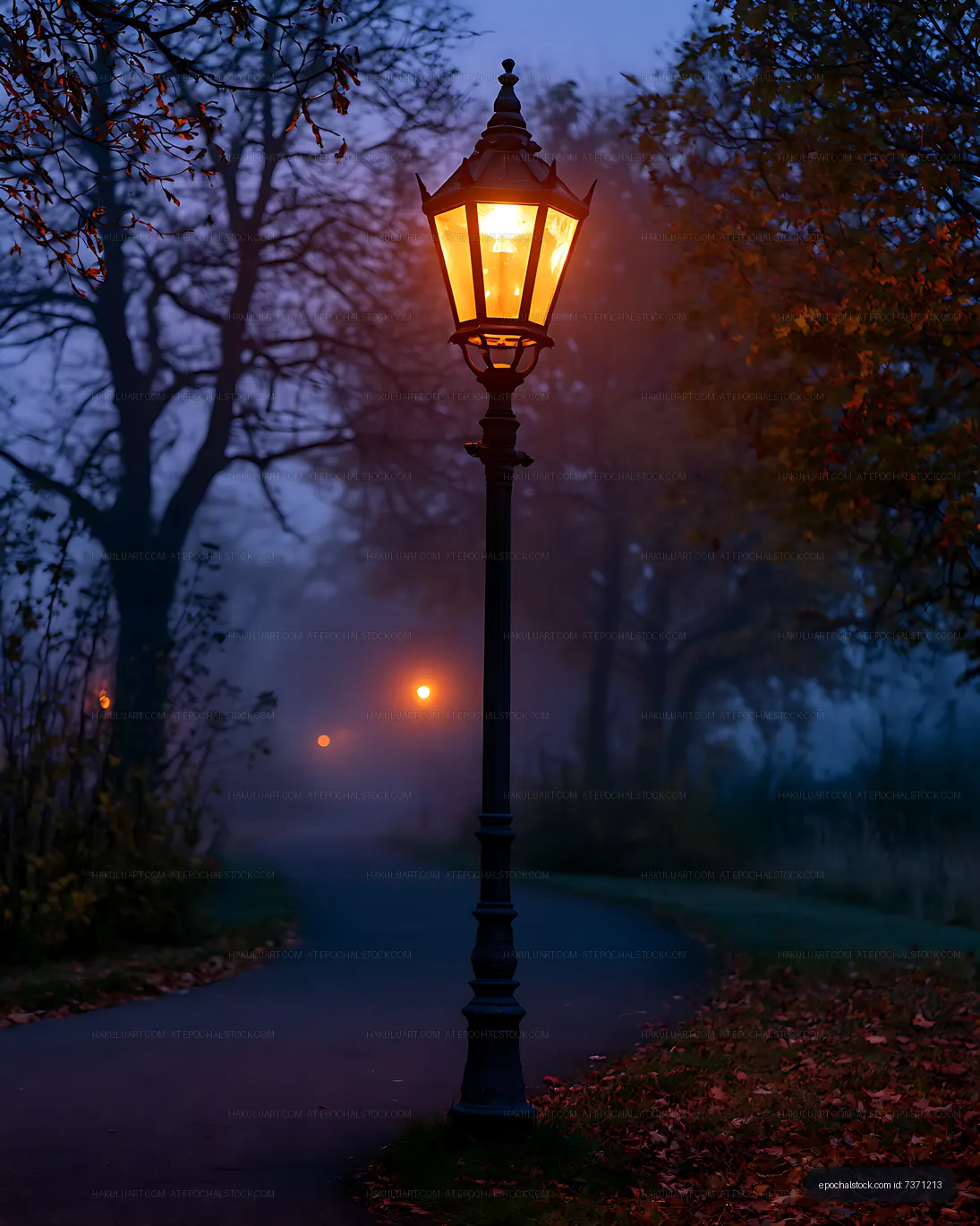 Warm street lantern glowing in an autumn park at twilight