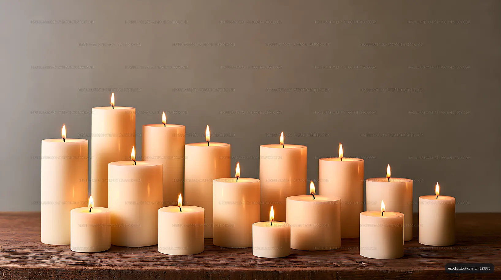 Lit pillar candles creating a warm still life on wood