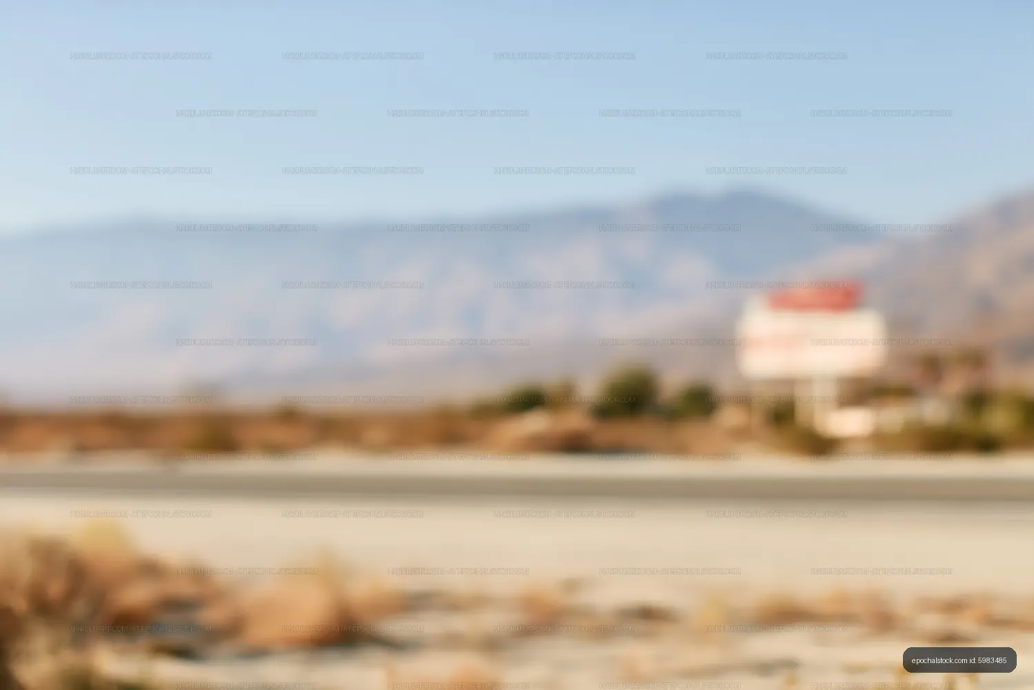 Defocused sandy roadside landscape with mountains