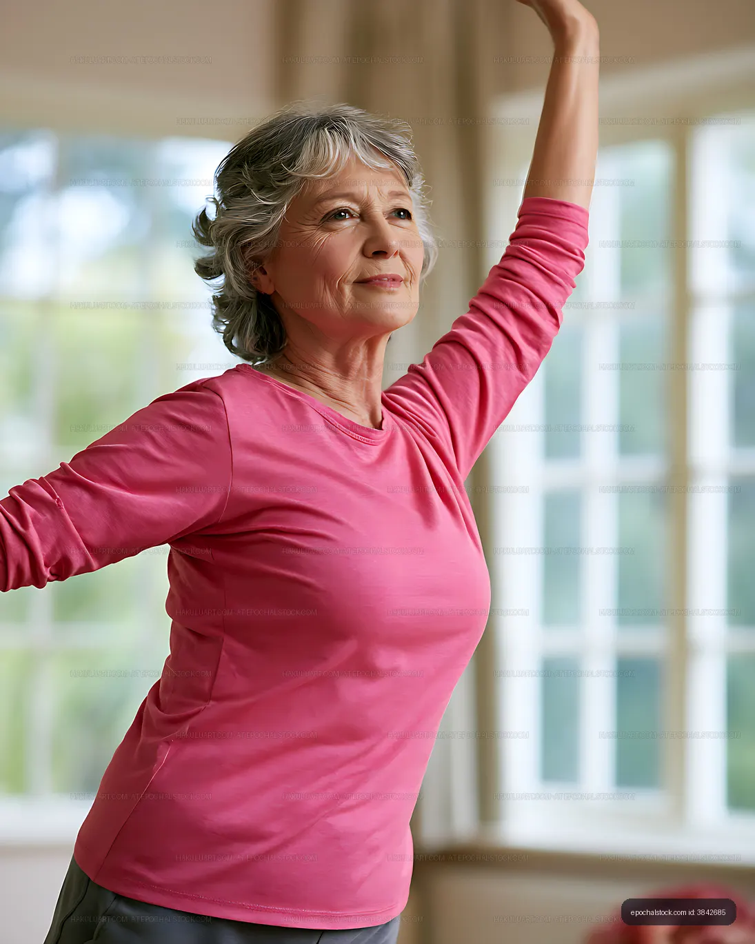 Active older woman stretching in a bright room
