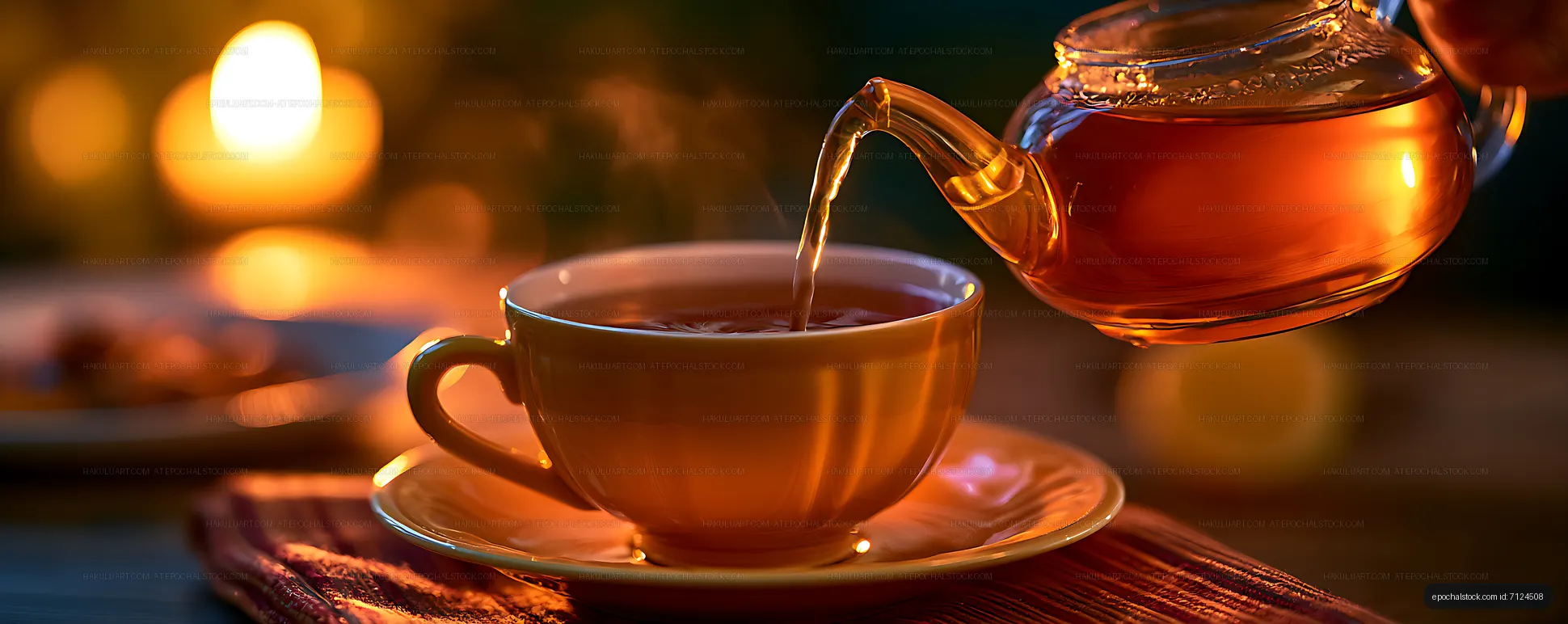 Warm candlelit tea pouring scene with glass teapot