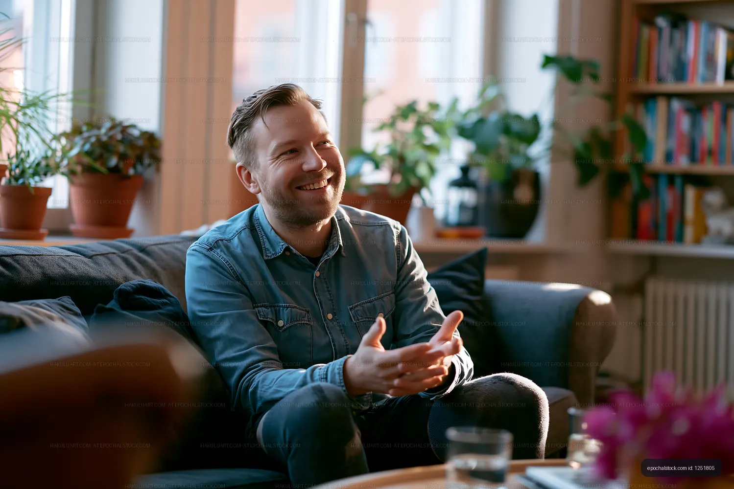 Smiling man seated on sofa in plant-filled living room