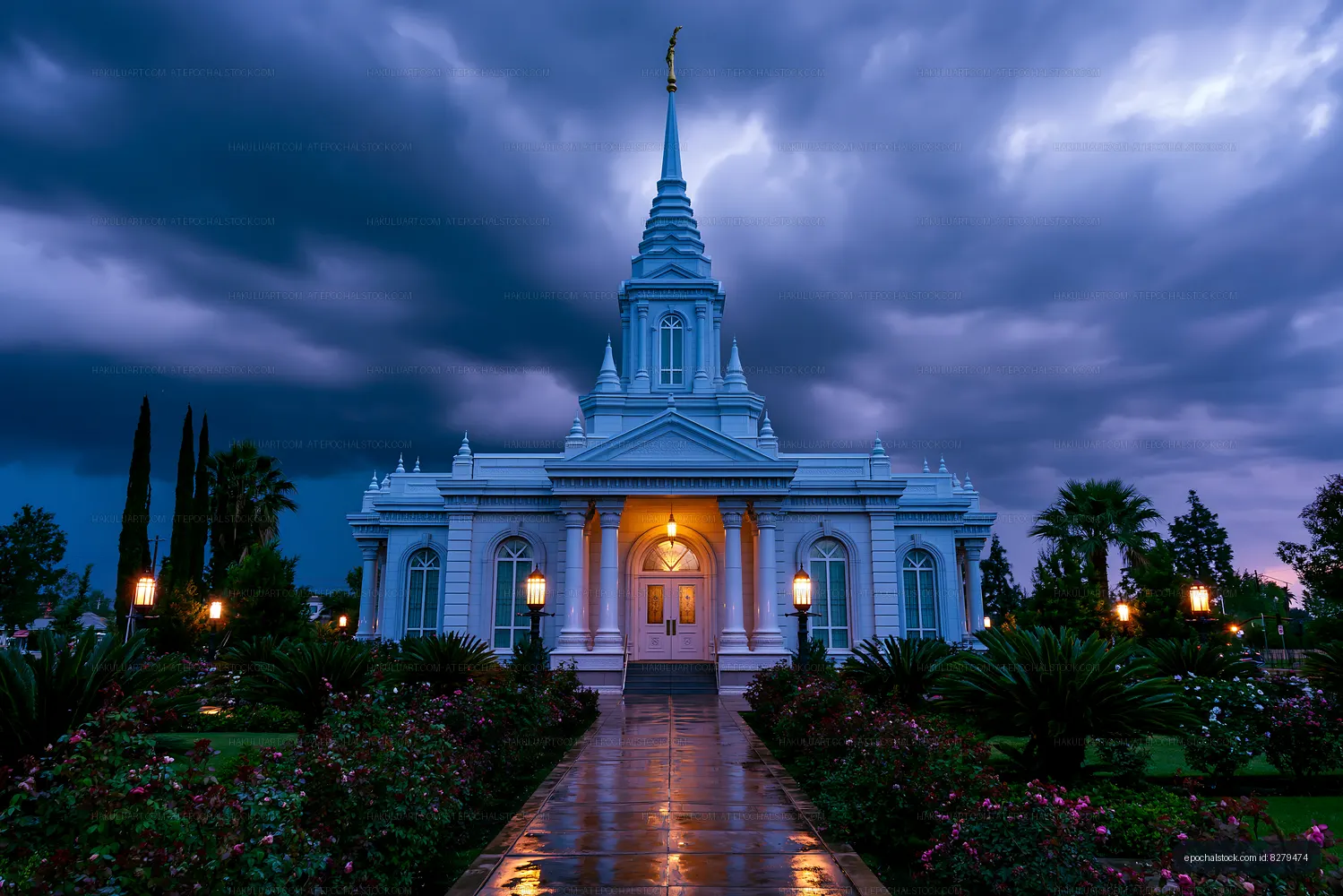 White spired temple illuminated after rain at dusk