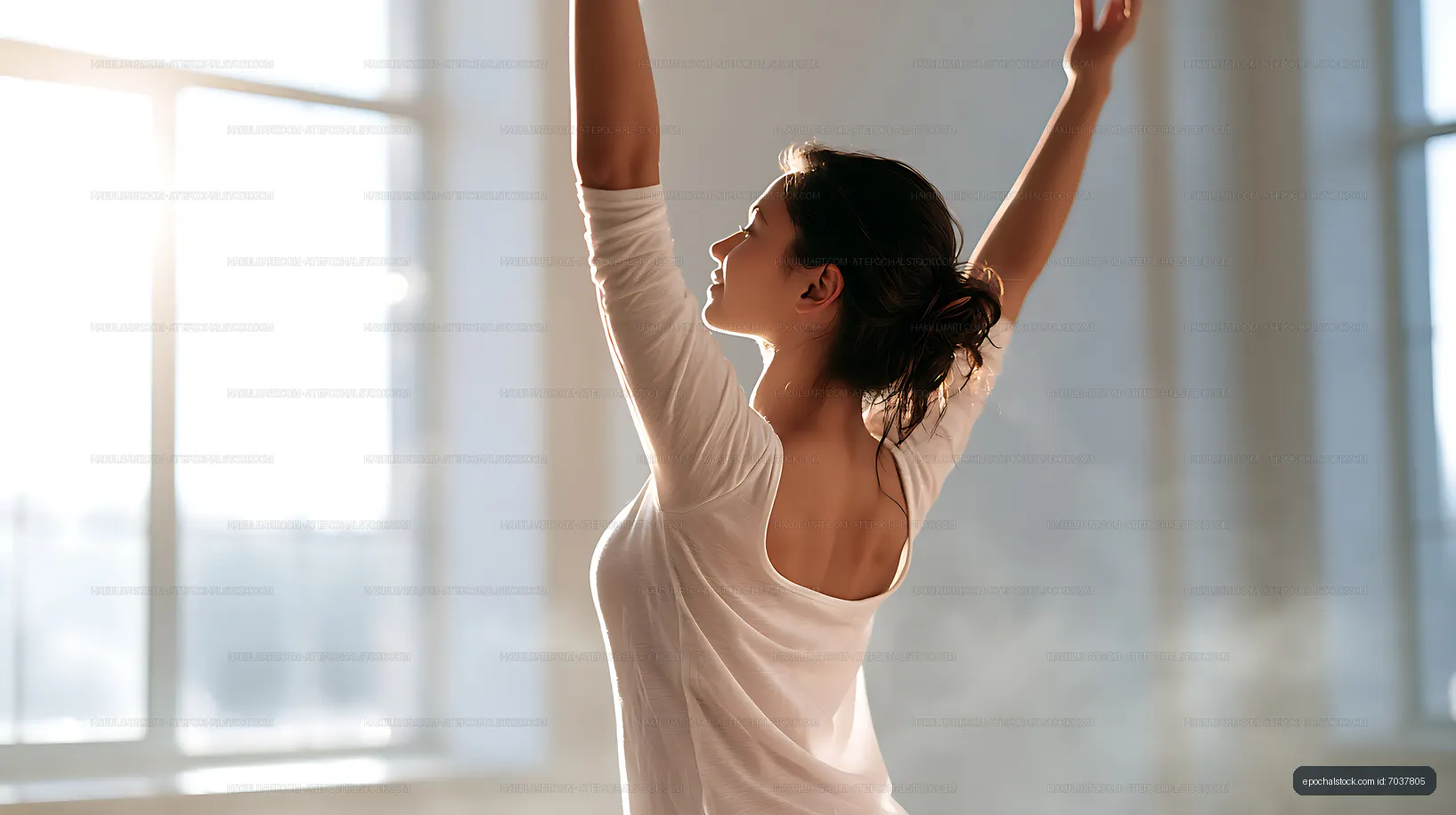 Side view of woman stretching near large windows