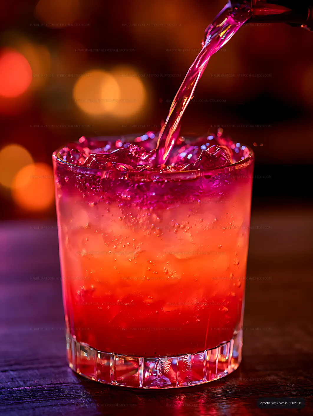Dramatic close-up of red cocktail being poured