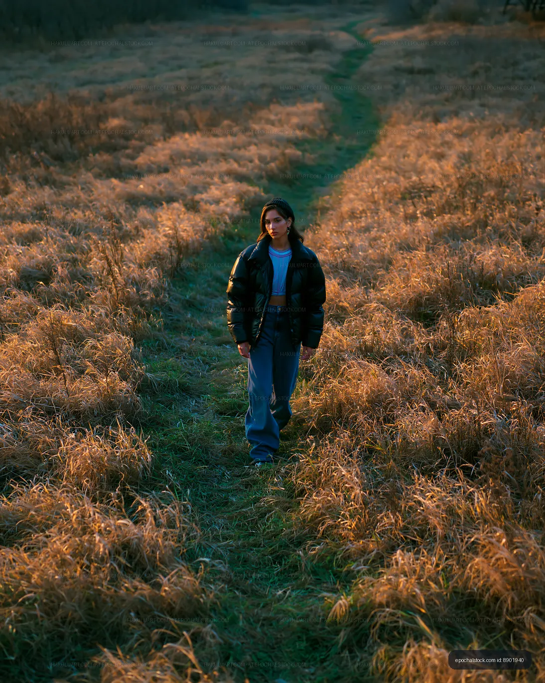 Woman Walking Through a Sunlit Grass Field