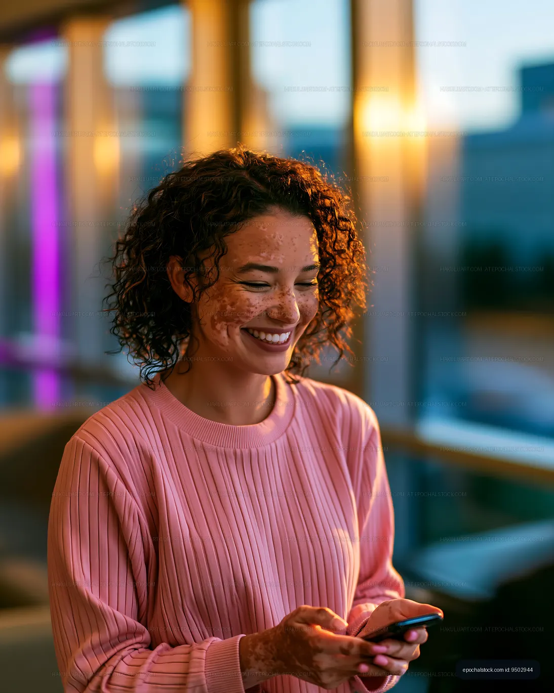 Freckled woman smiling while holding a smartphone