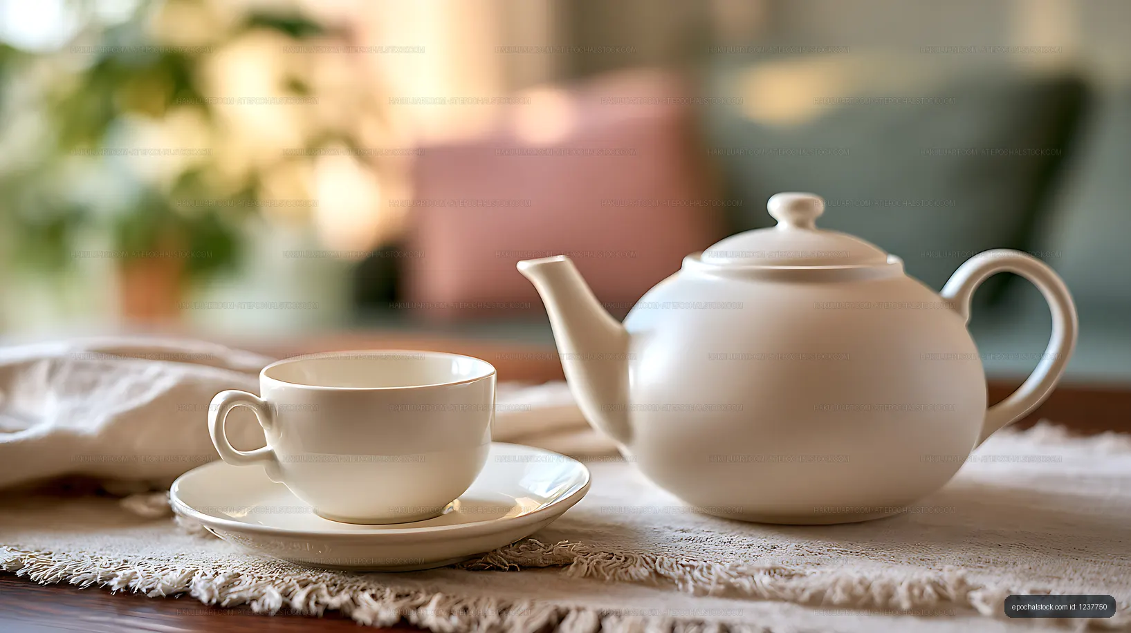 White ceramic teapot and cup on textured table linen