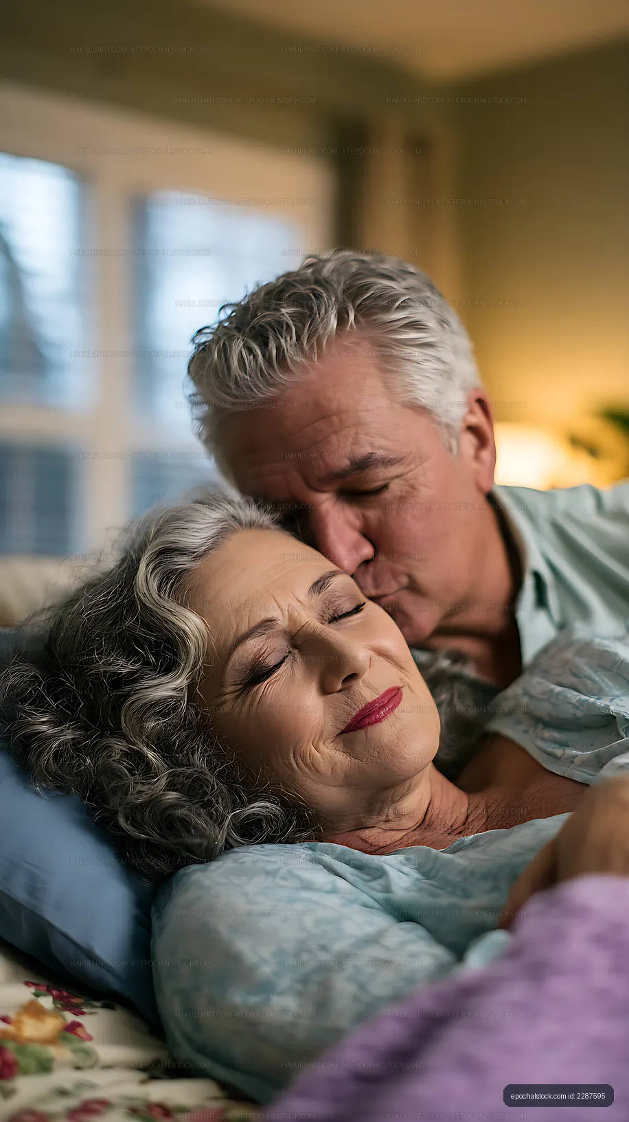 Tender older couple kissing at home in bed