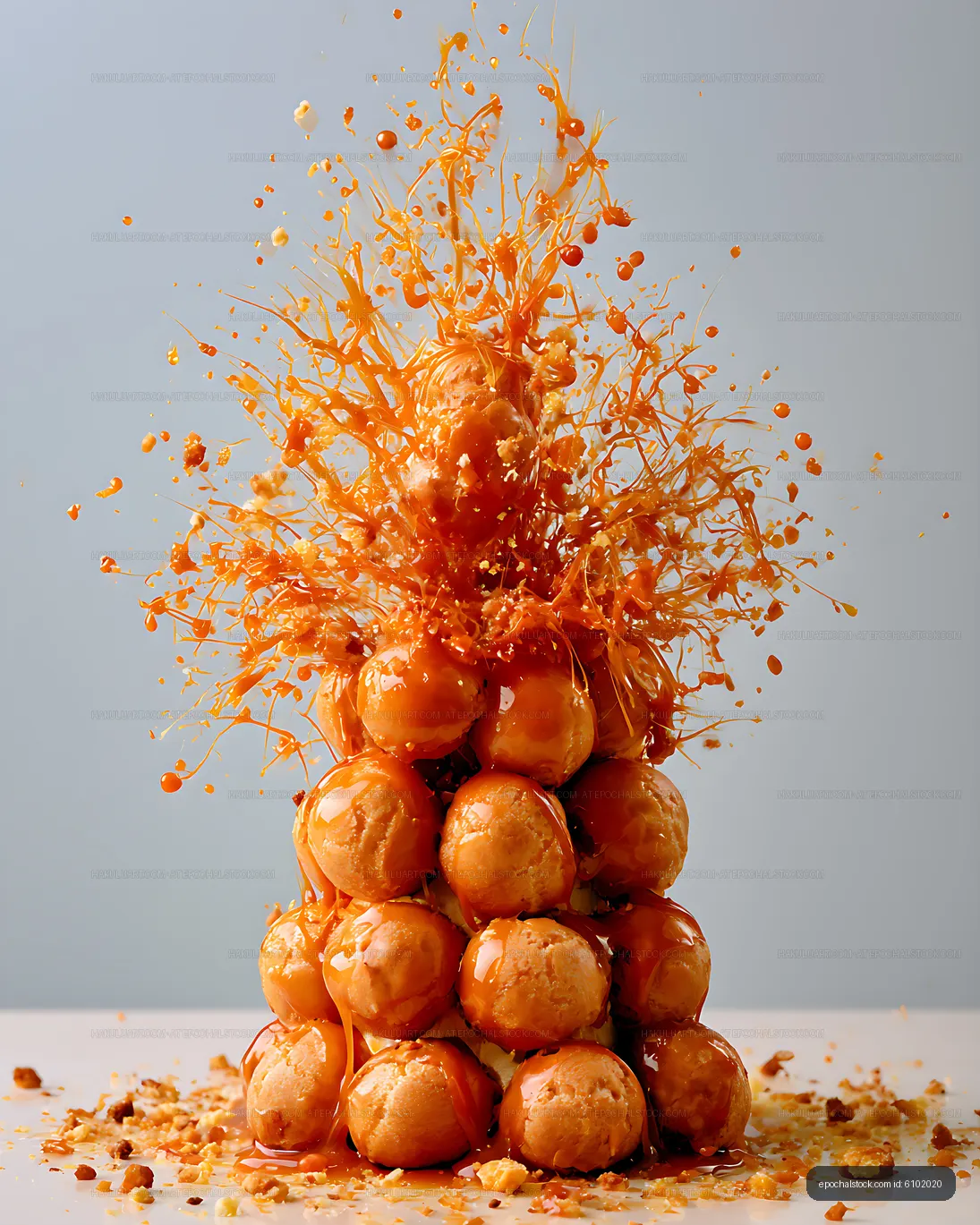 Dramatic caramel splash over an orange dessert tower