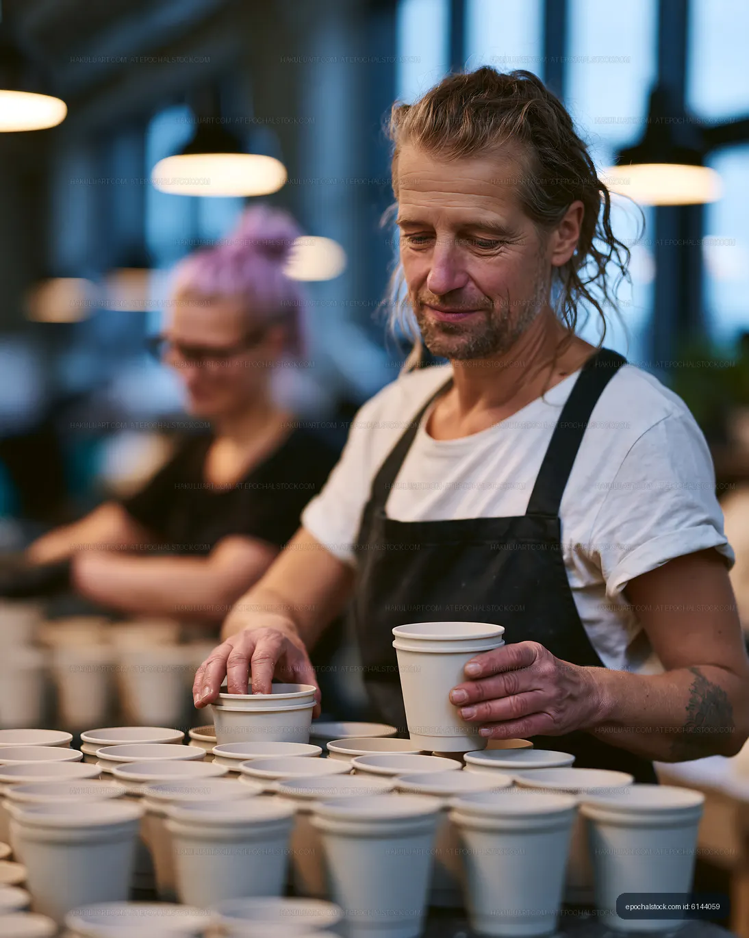 Barista arranging cups at a coffee counter
