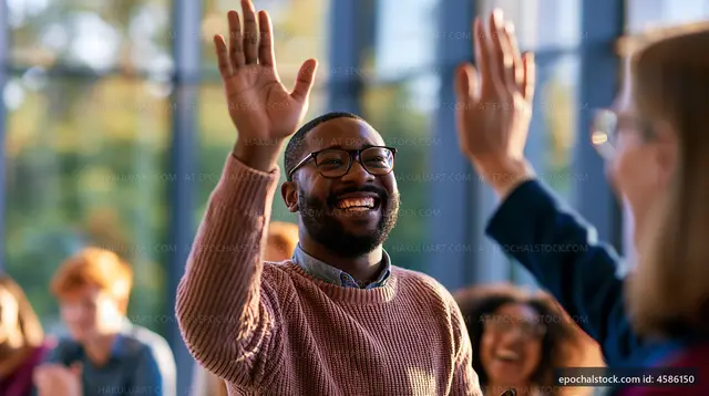 Man waving hand during group discussion in bright meeting space