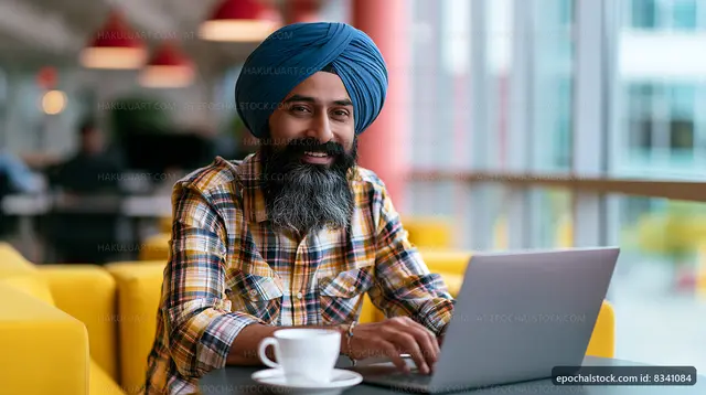 Man working on laptop in cafe with coffee in hand