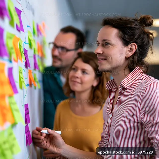 Team brainstorming with sticky notes on whiteboard in office