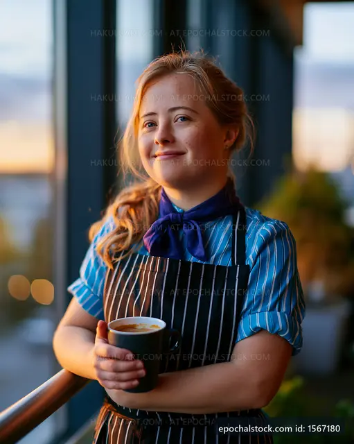 Barista holding coffee cup near large window at sunset