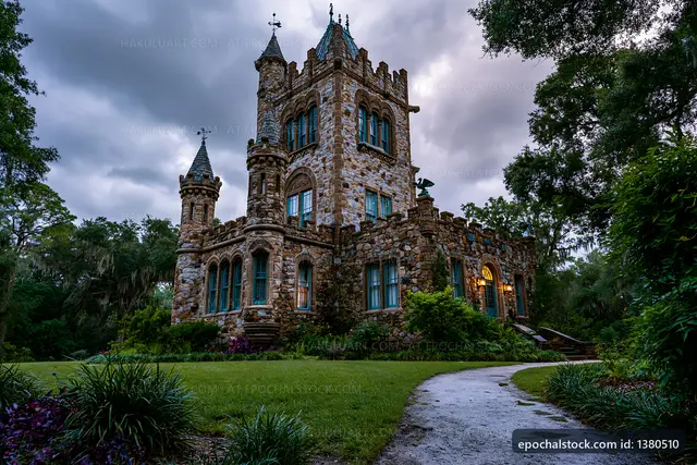 Historic stone castle surrounded by trees at dusk