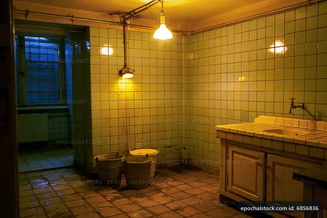 Abandoned bathroom with blue lighting and tiled walls