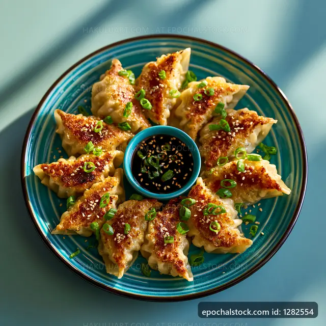 Dumplings served on a blue plate with sauce and green onions