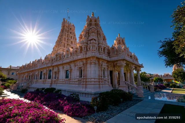 Temple surrounded by flowers and sunlight in clear sky