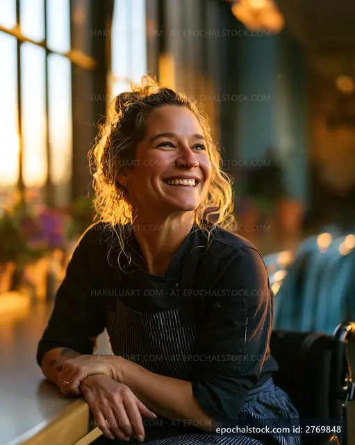 Smiling woman in apron at a sunny cafe interior